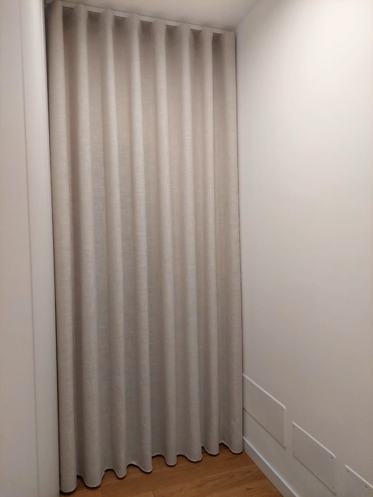 Una tenda bianca è appesa alla finestra di una stanza.