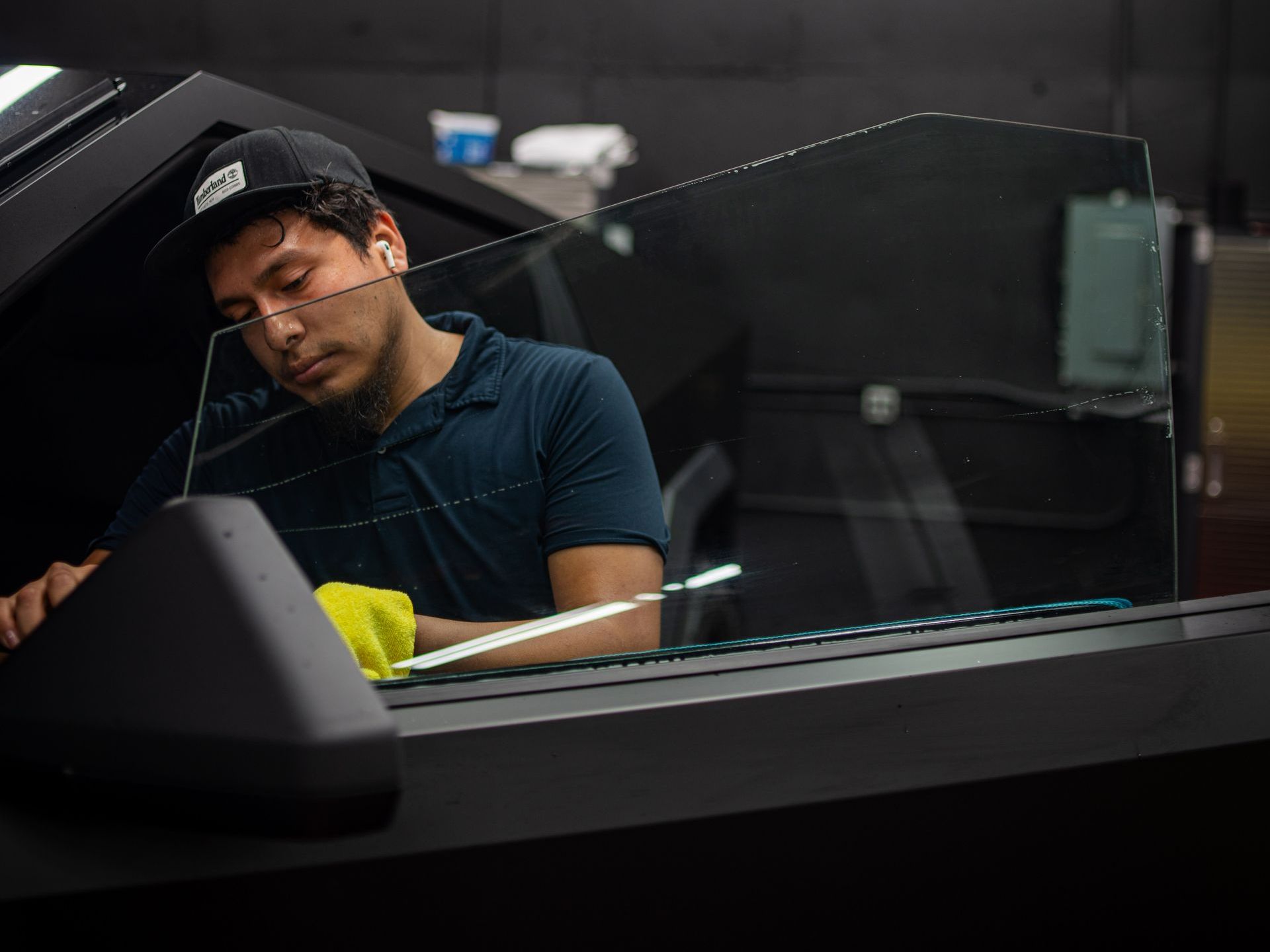 A man is cleaning the windshield of a car.