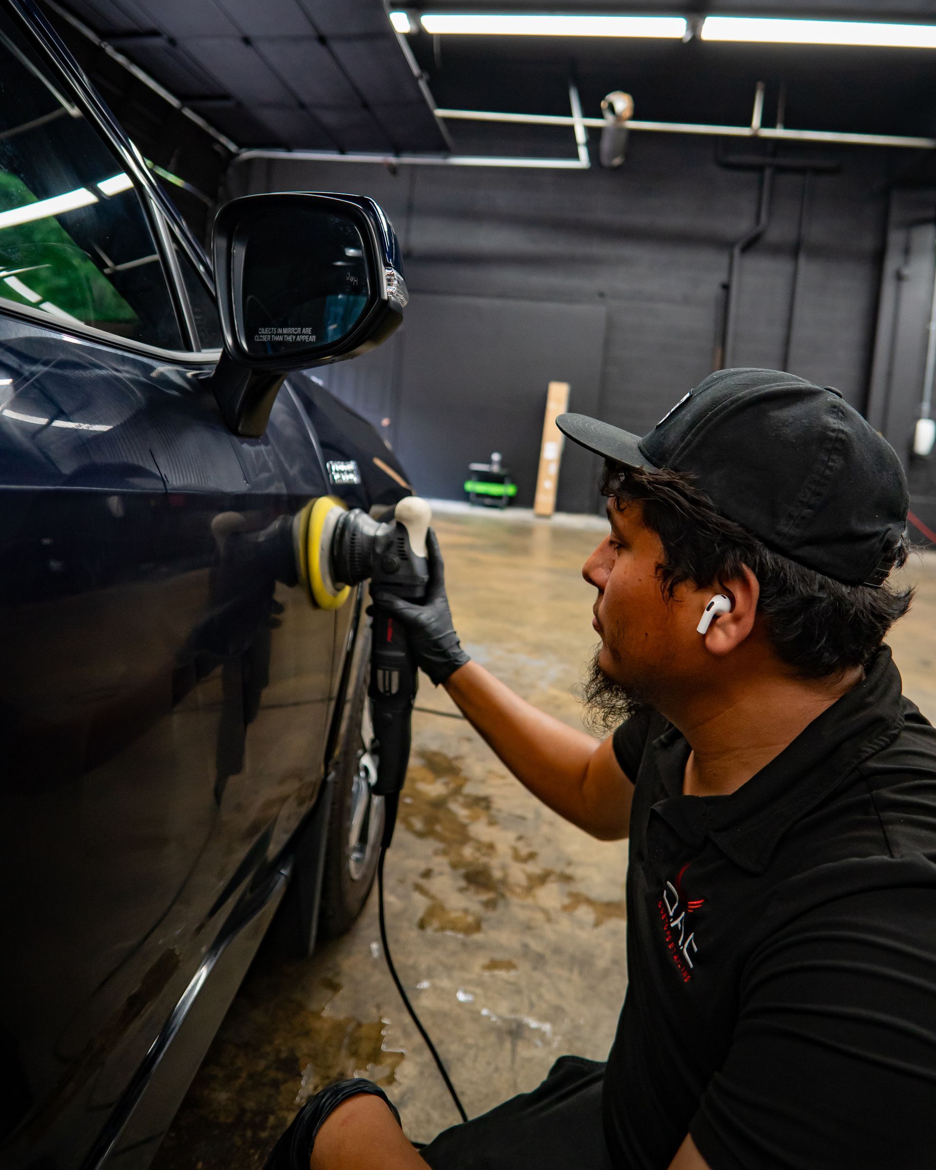 A man is polishing a car in a garage