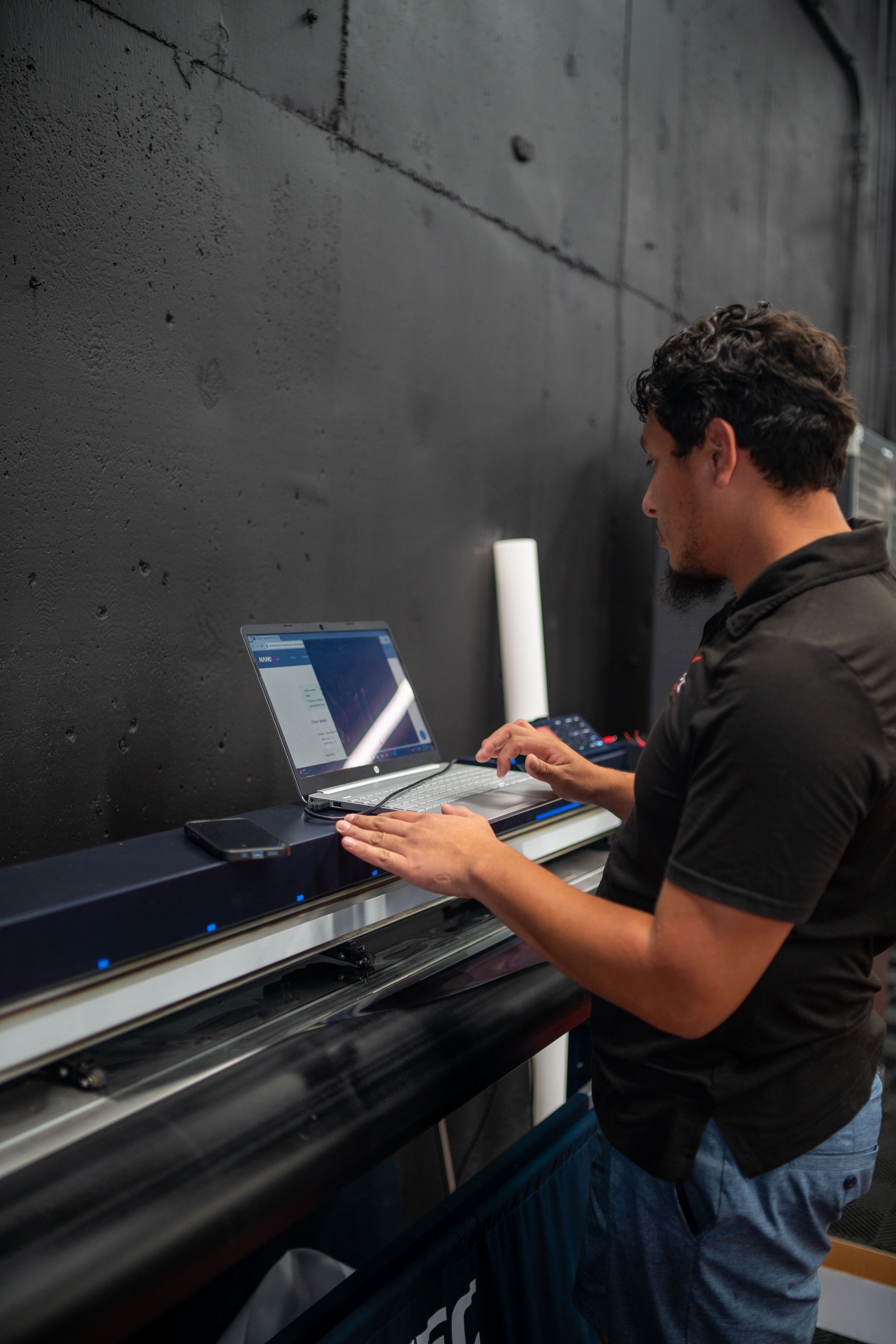 A man is using a laptop computer in a dark room.