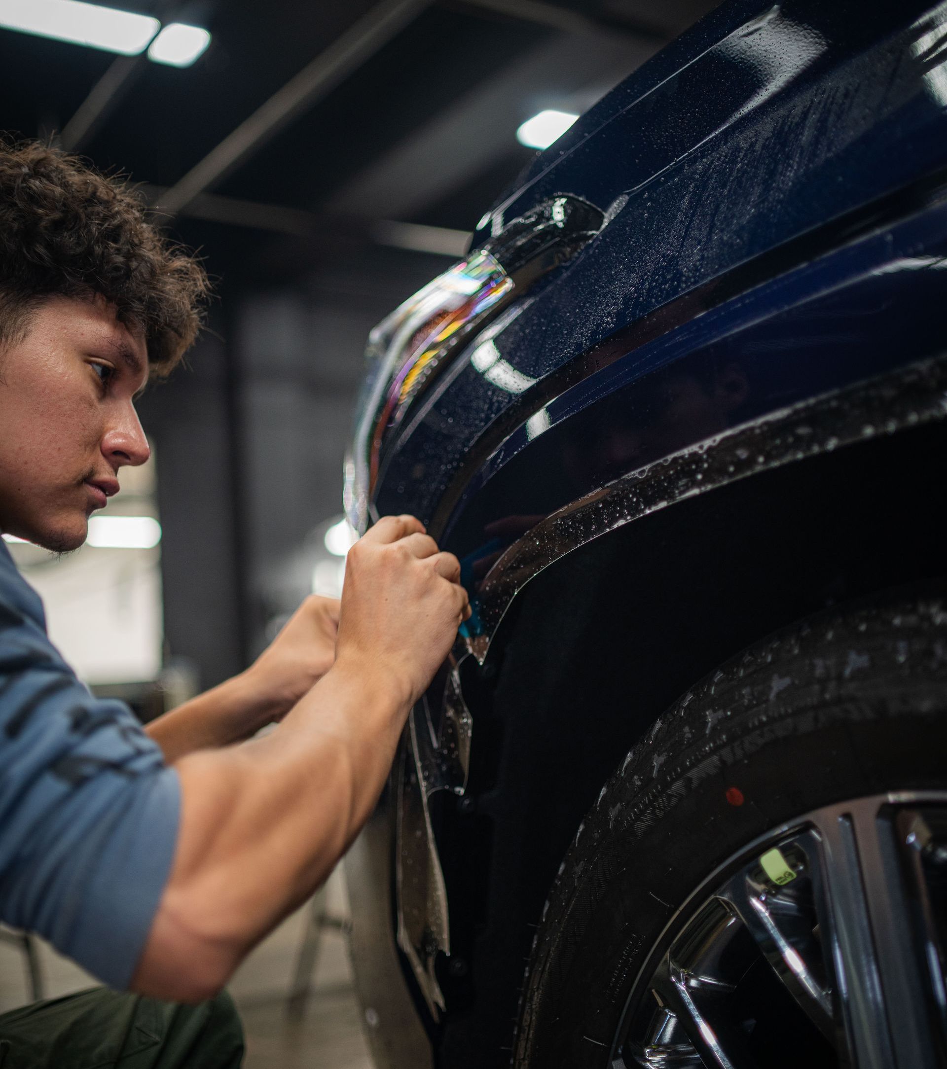 A man is working on the front of a ford truck