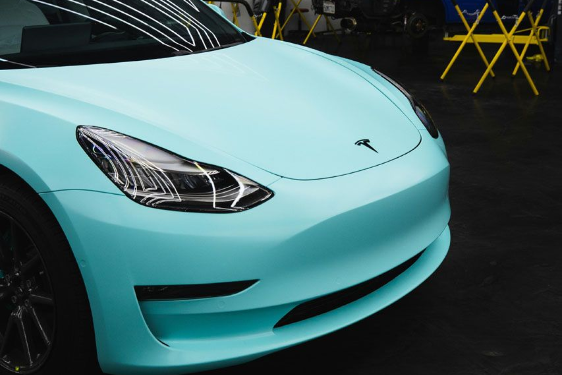 A white porsche panamera is parked in front of a building.