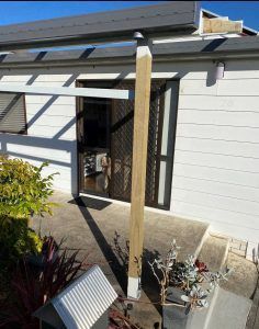 A White House With a Wooden Post in Front of It — Superior Windows & Doors Taree, NSW