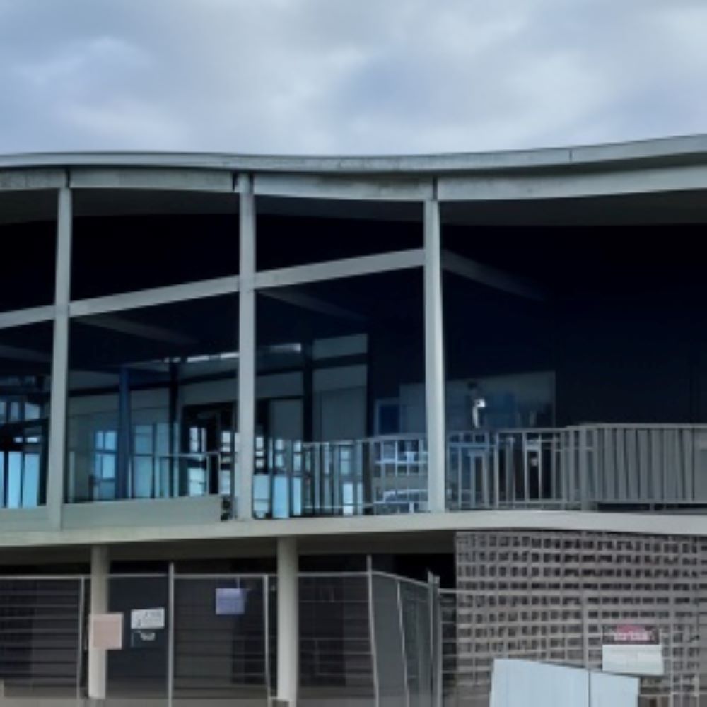 A Large Building With a Lot of Windows and a Fence Around It — Superior Windows & Doors Taree, NSW