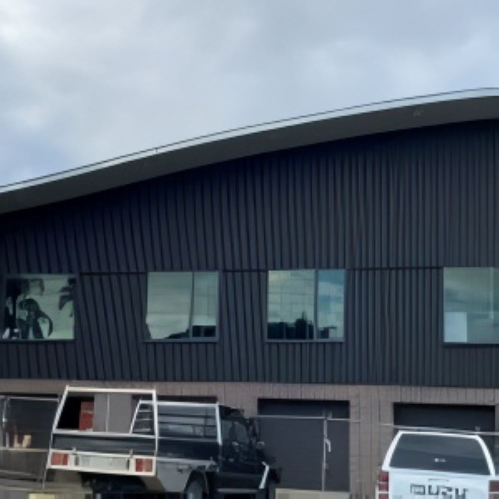 A Truck is Parked in Front of a Large Building — Superior Windows & Doors Taree, NSW