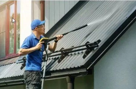 picture of a man pressure washing a roof