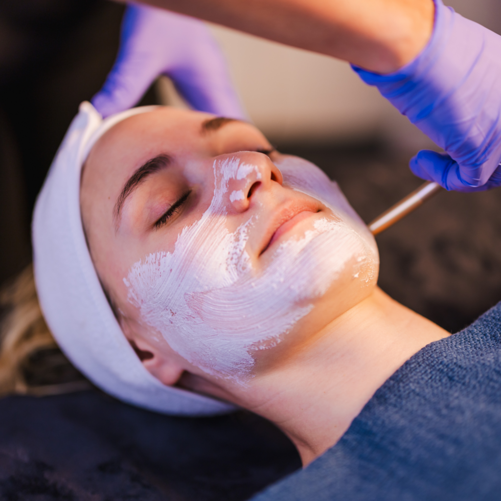 A woman is getting a facial treatment with a mask on her face.