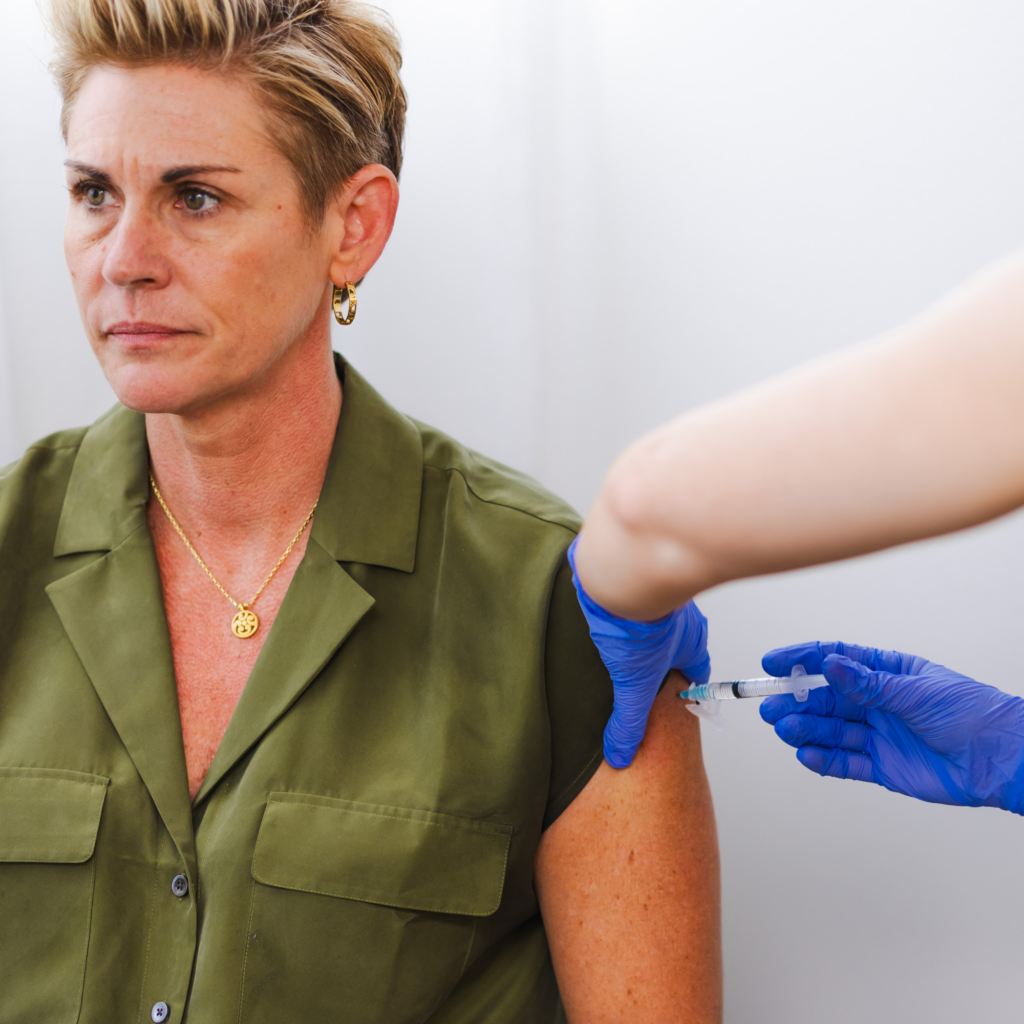 A woman is getting an injection in her arm