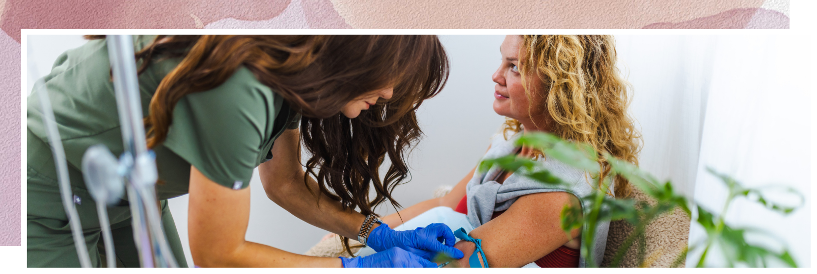 A woman is holding a baby in her arms while a nurse looks on.