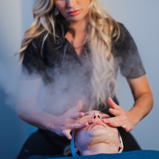 A woman is applying steam to a man 's face