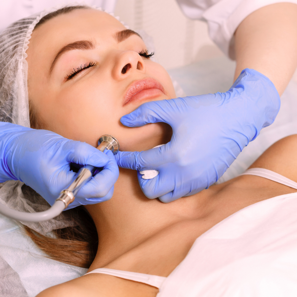 hands performing facial services on woman's face