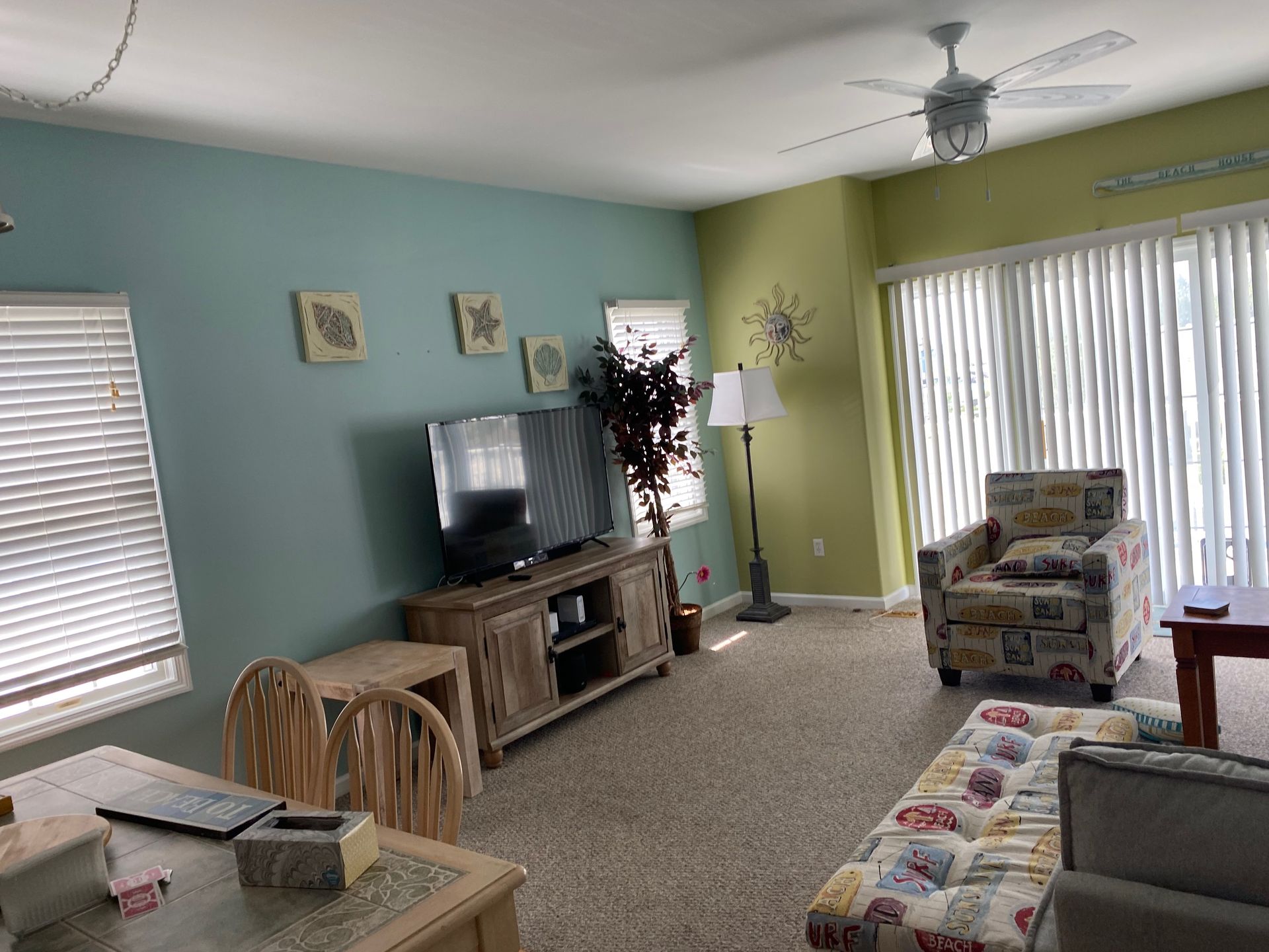 A living room with a couch , chair , table and television.