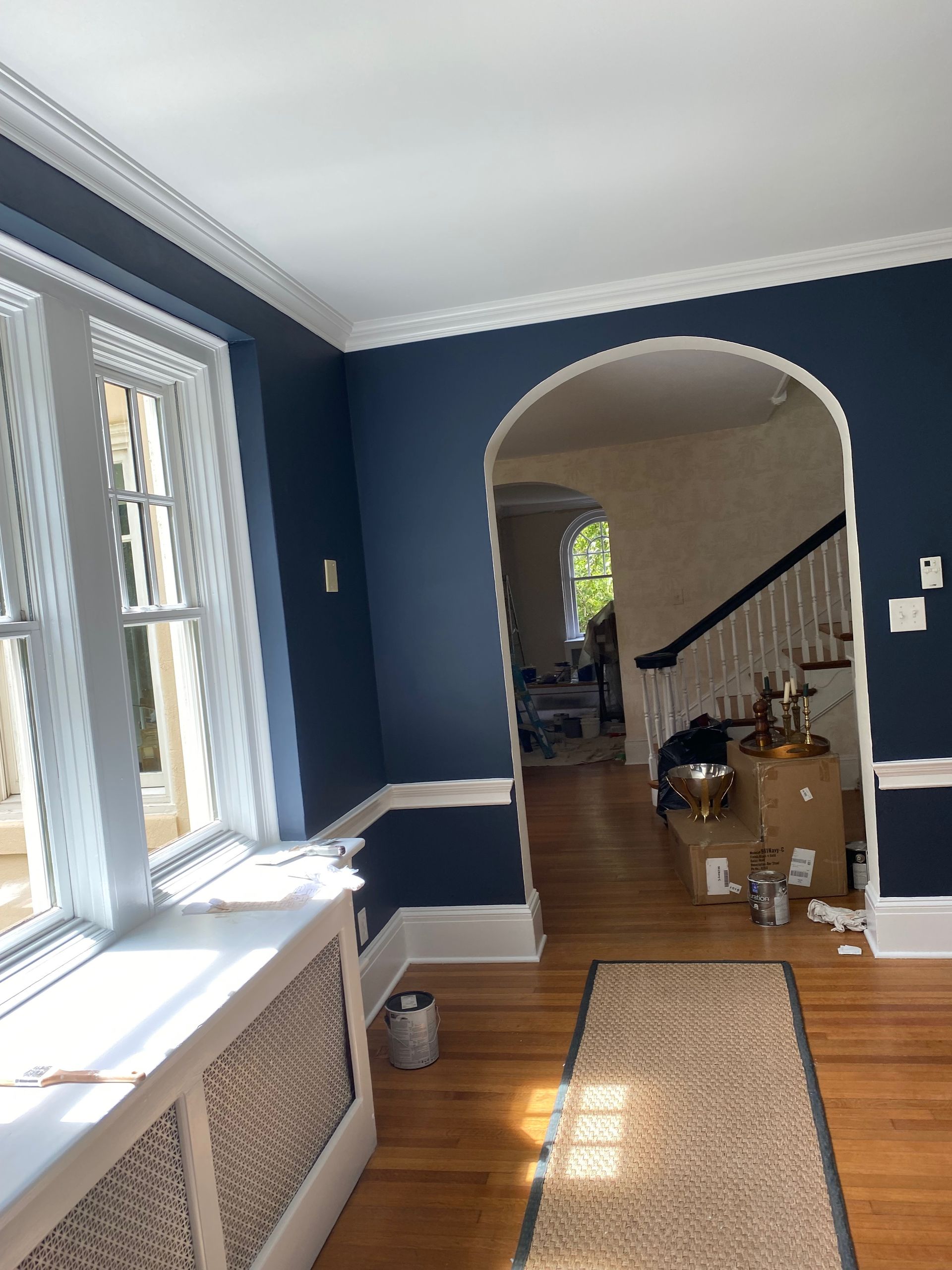 A living room with dark blue walls and white trim