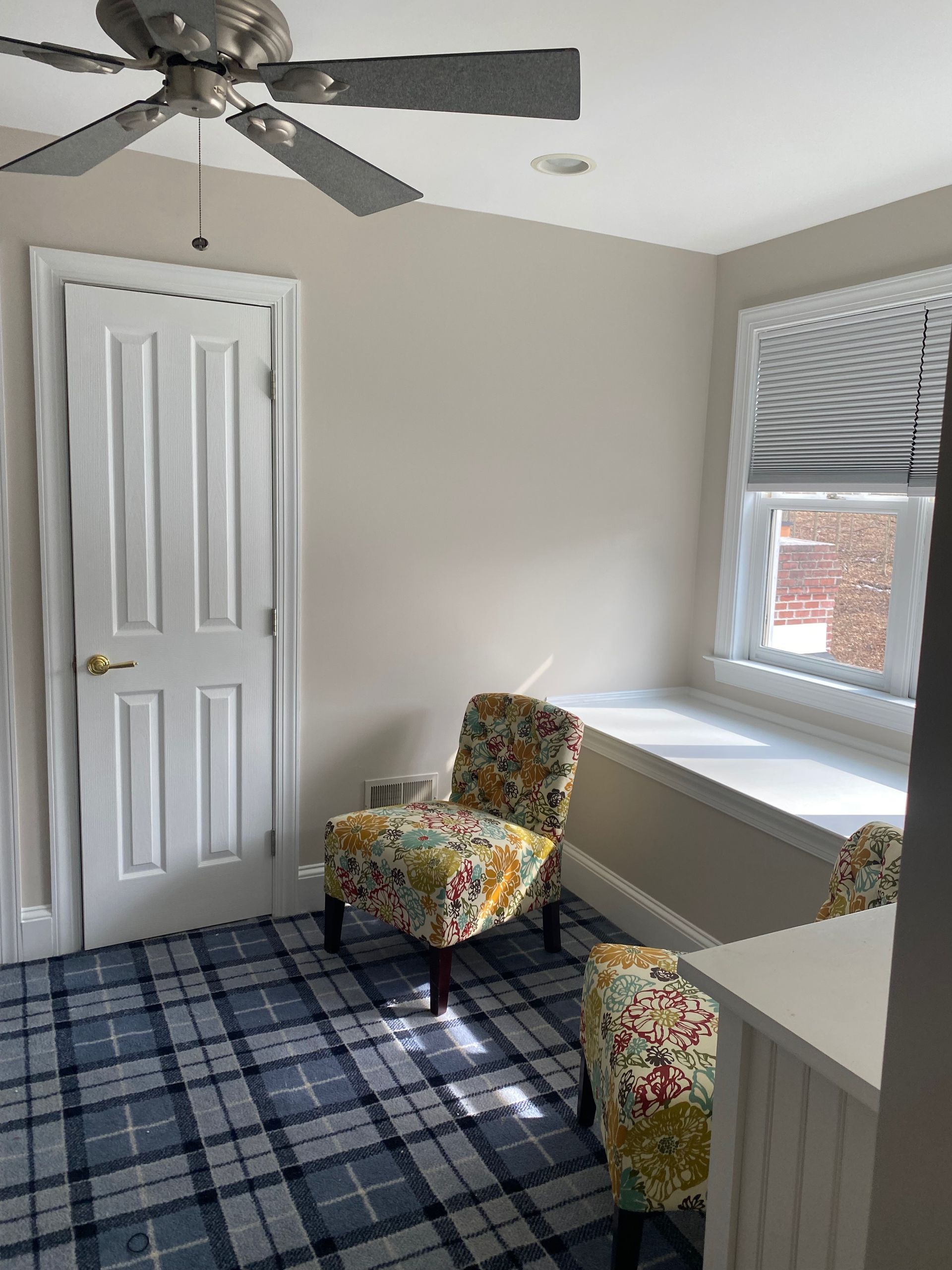A room with two chairs and a ceiling fan