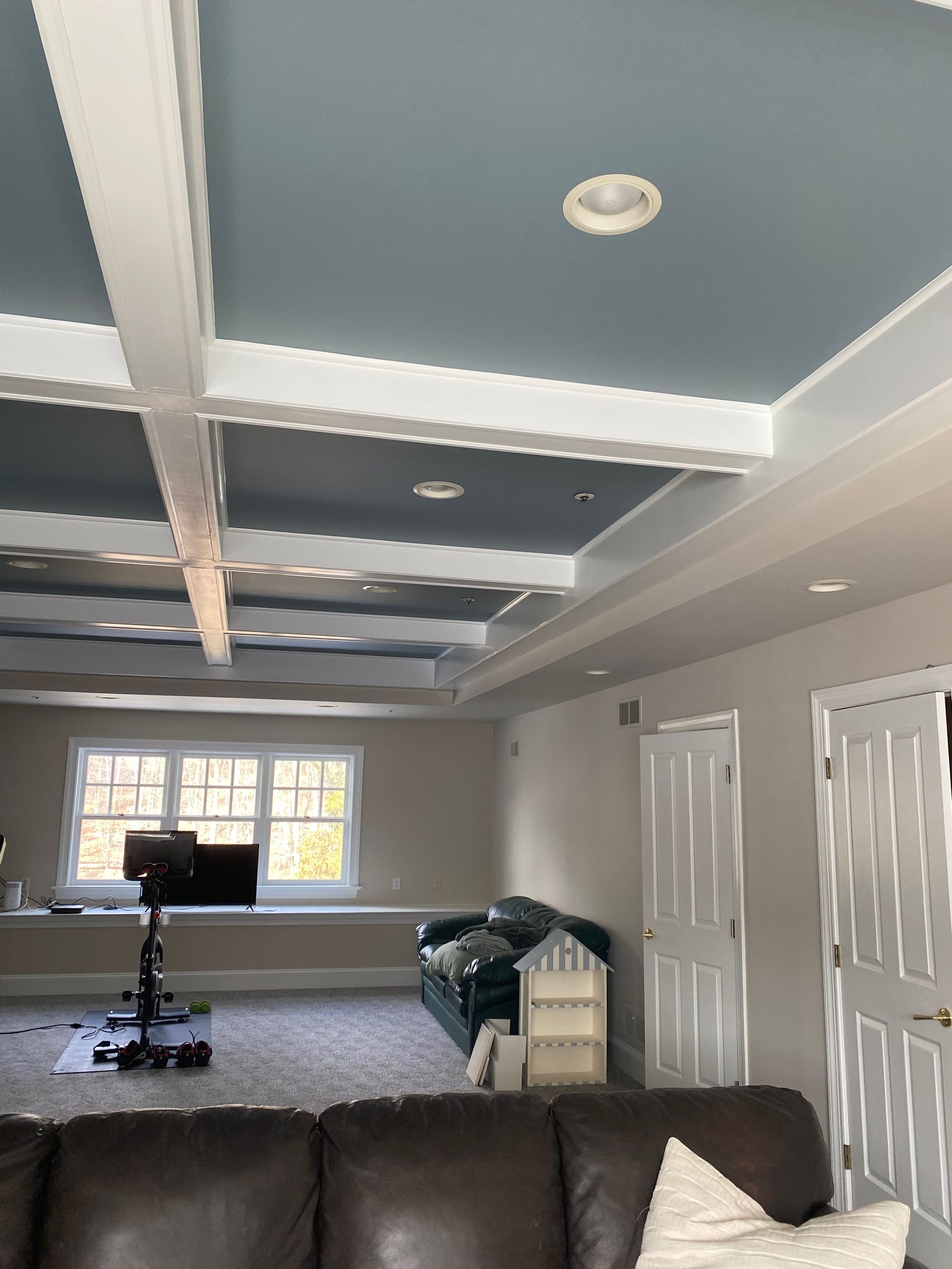 A living room with a blue ceiling and a brown couch