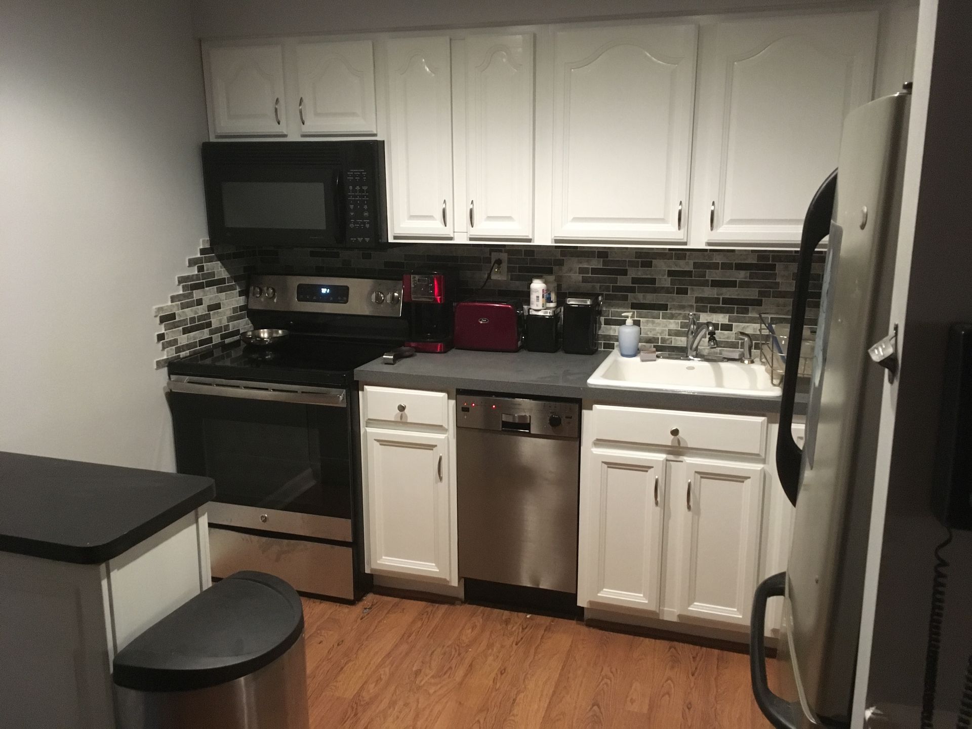 A kitchen with white cabinets and stainless steel appliances