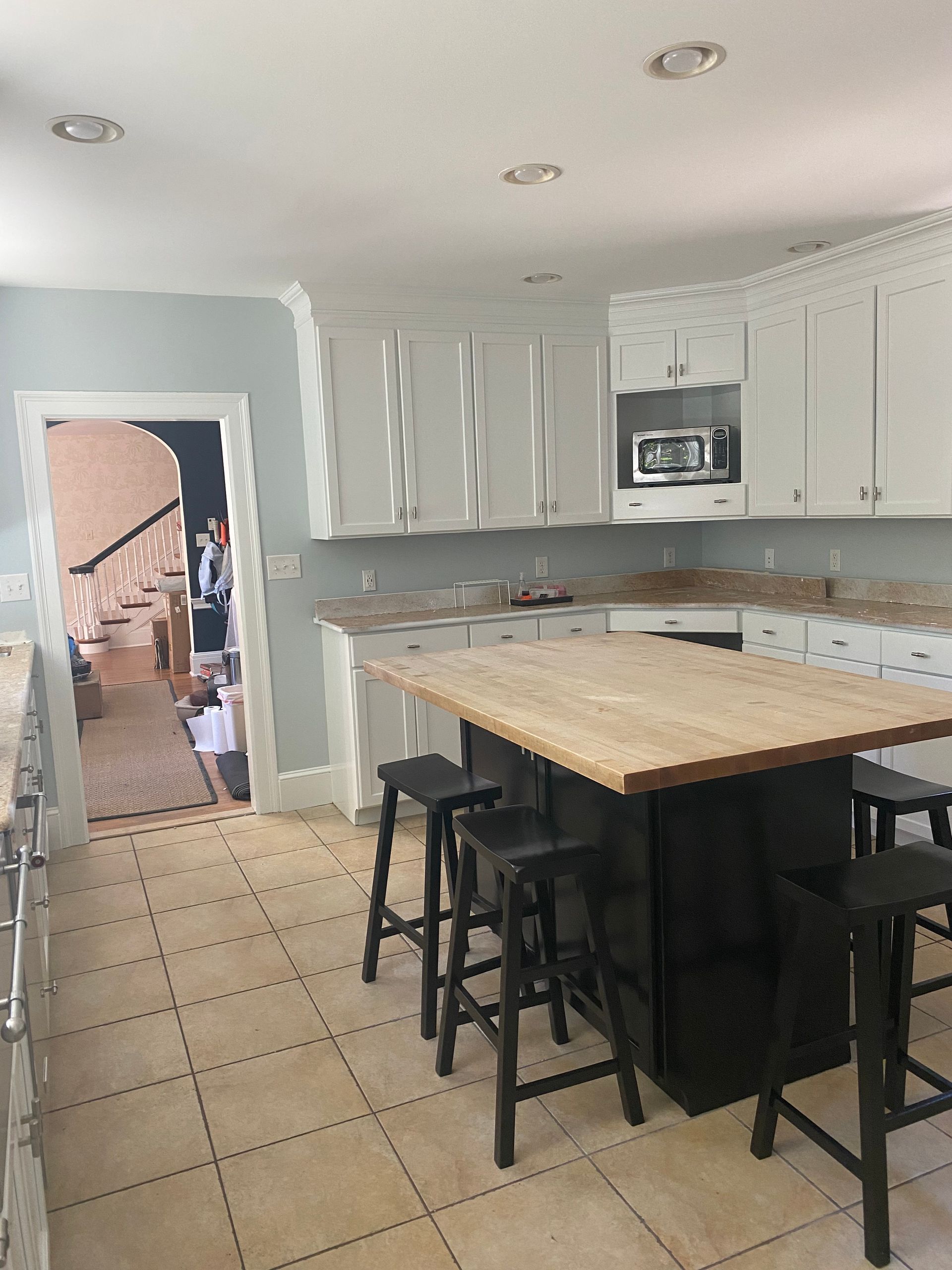 A kitchen with a large wooden table and stools