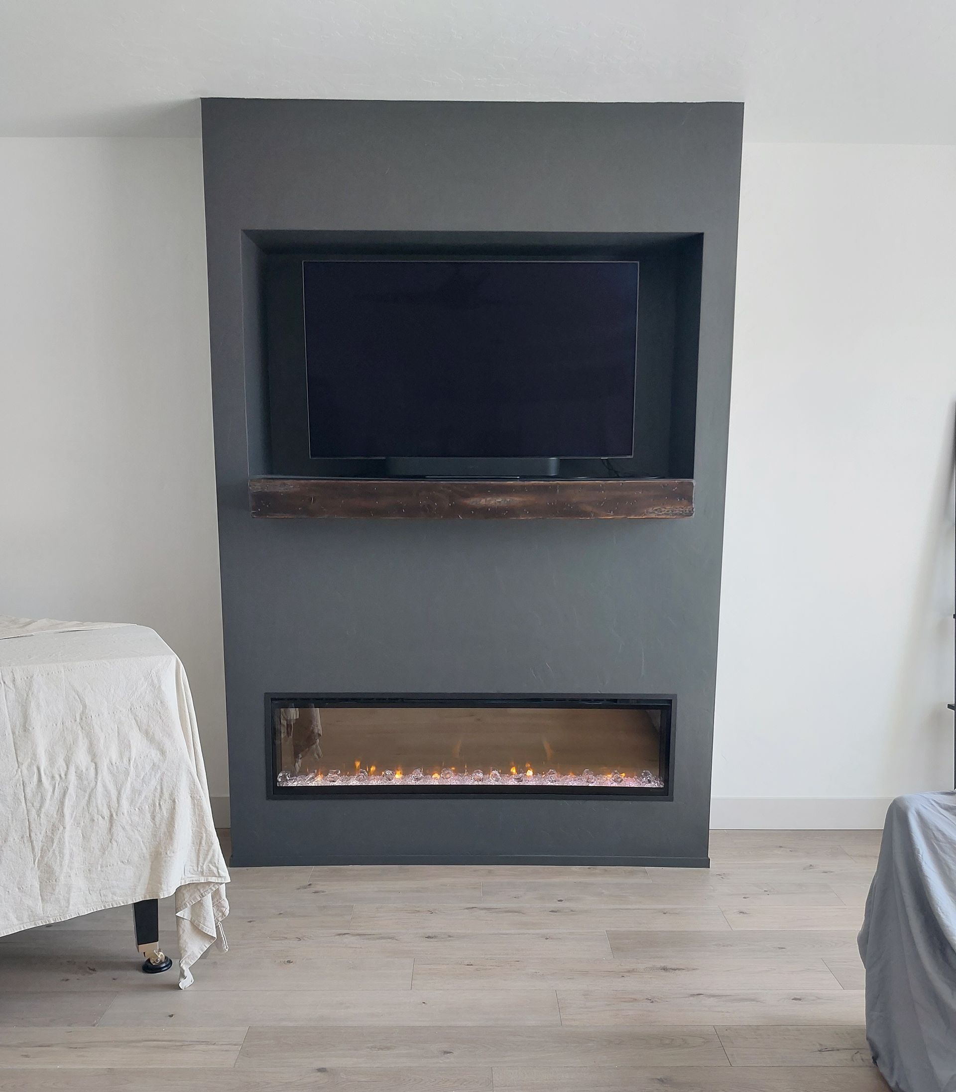 A living room with a fireplace and a flat screen tv mounted to the wall.