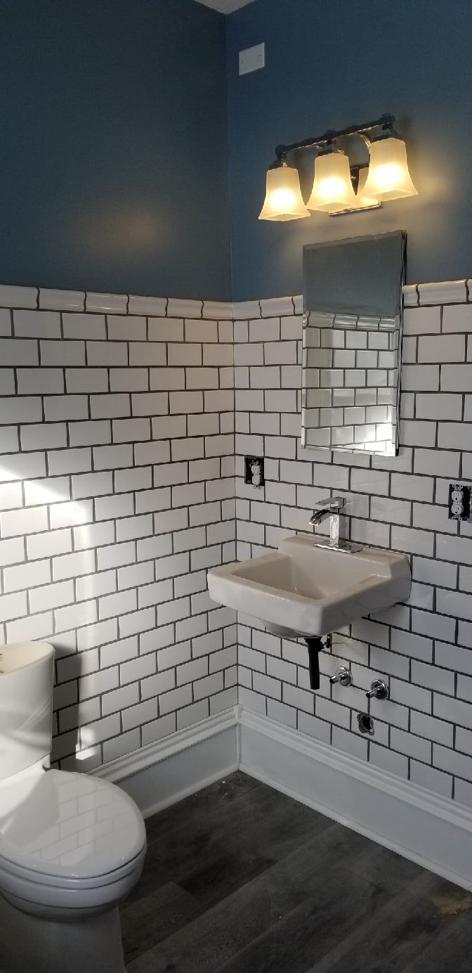 A bathroom with a toilet , sink and mirror