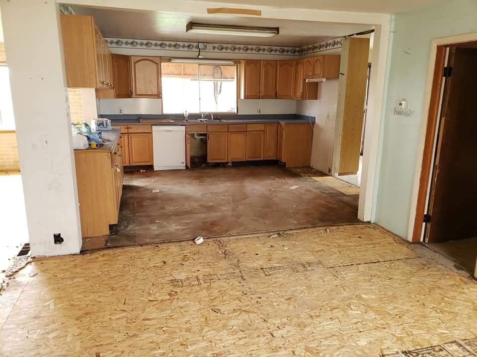 A kitchen with wooden cabinets , a sink , and a dishwasher.