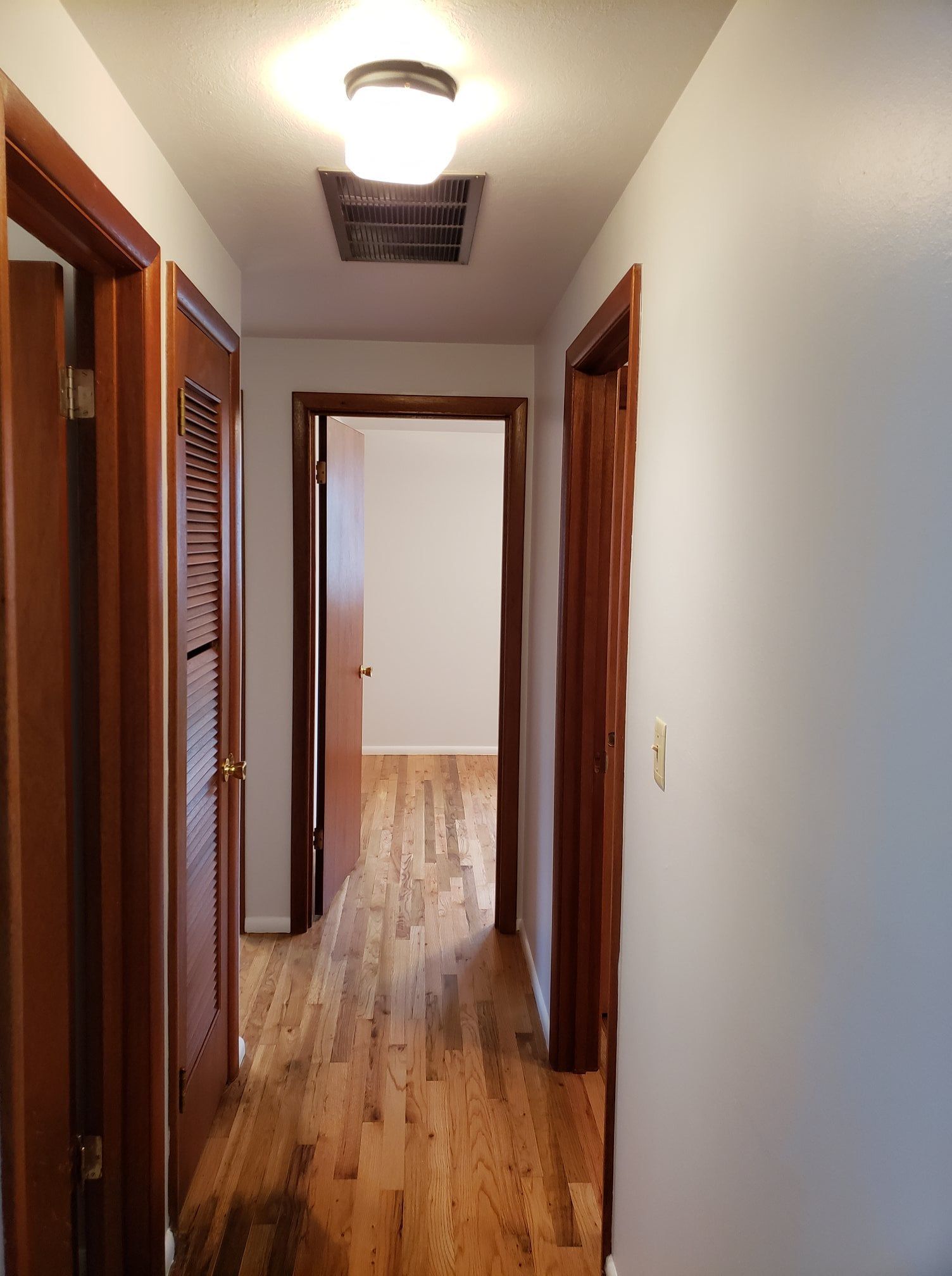 A hallway with wooden floors and white walls