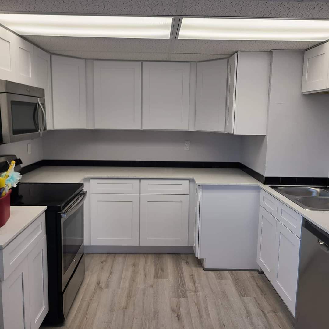 A kitchen with white cabinets and stainless steel appliances
