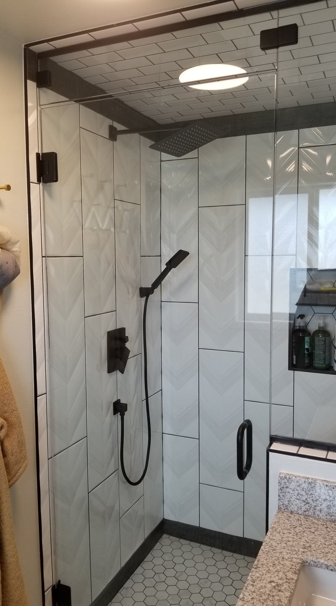 A bathroom with a walk in shower and a sink.