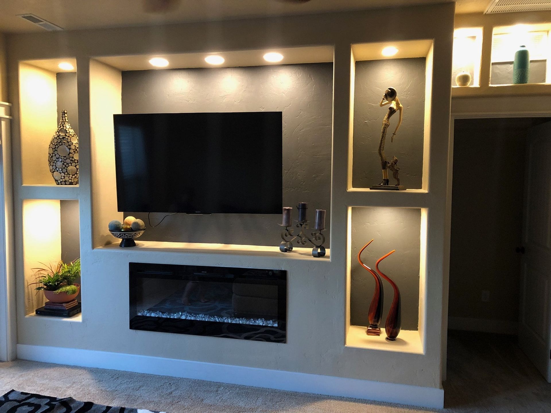 A living room with a fireplace and a flat screen tv.