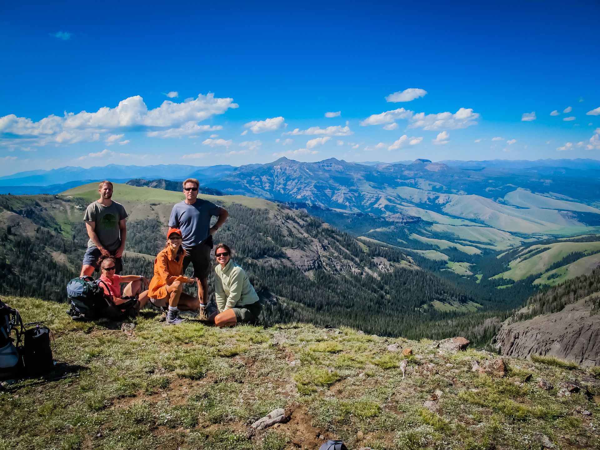 A small group of backpackers pose for a photo on the wind swept summit of Bighorn Peak in Yellowstone National Park.