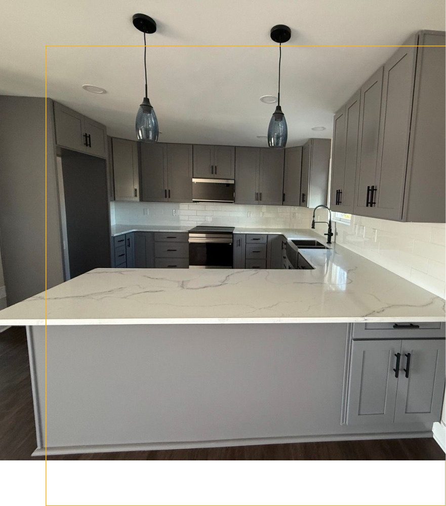 A kitchen with gray cabinetry, white marble-patterned countertops, a peninsula, and two hanging glass pendant lights.