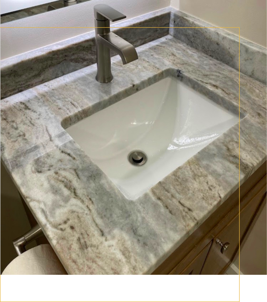 A bathroom vanity with a white rectangular sink, modern faucet, and marbled granite countertop.