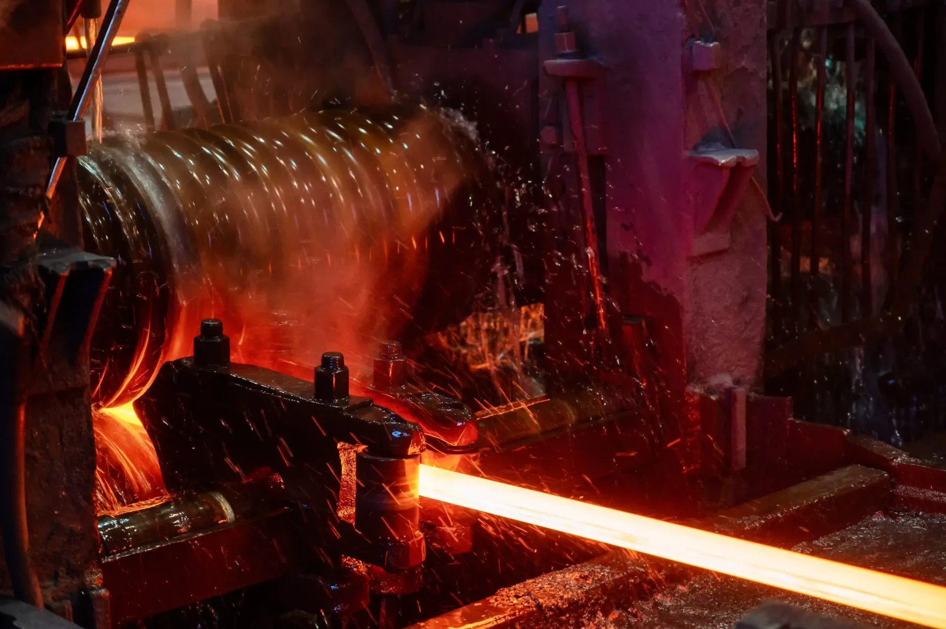 Heavy industrial machinery processing glowing red-hot steel during professional plate rolling servic