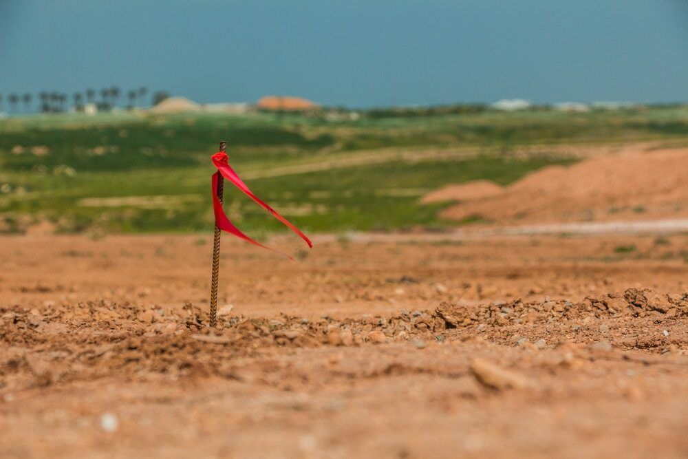 A Red Flag Is Stuck In The Middle Of A Dirt Field — Clarence Valley Surveys In Grafton, NSW