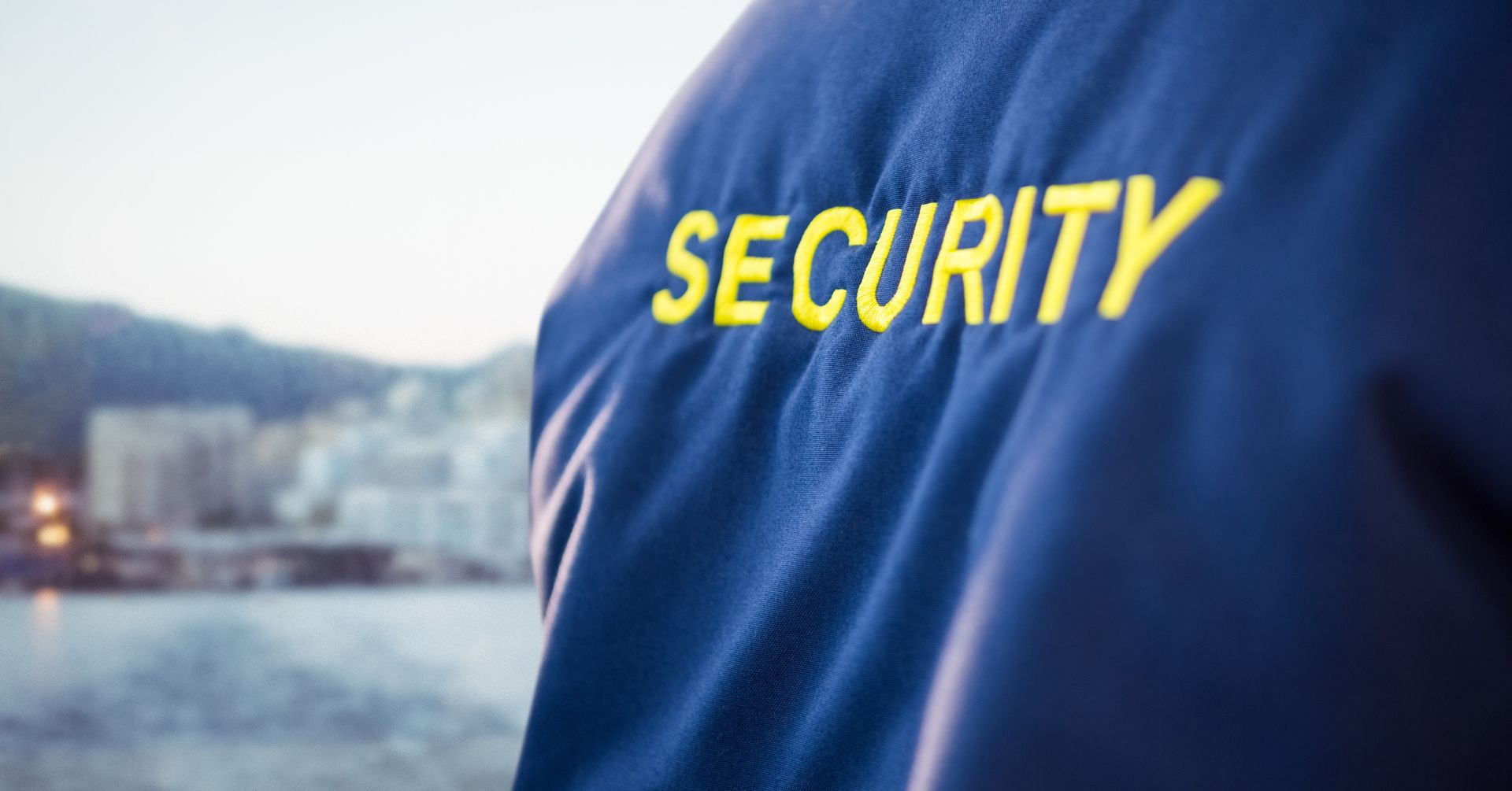 Back of security guard jacket against blurry skyline. Back of security guard jacket against blurry skyline.