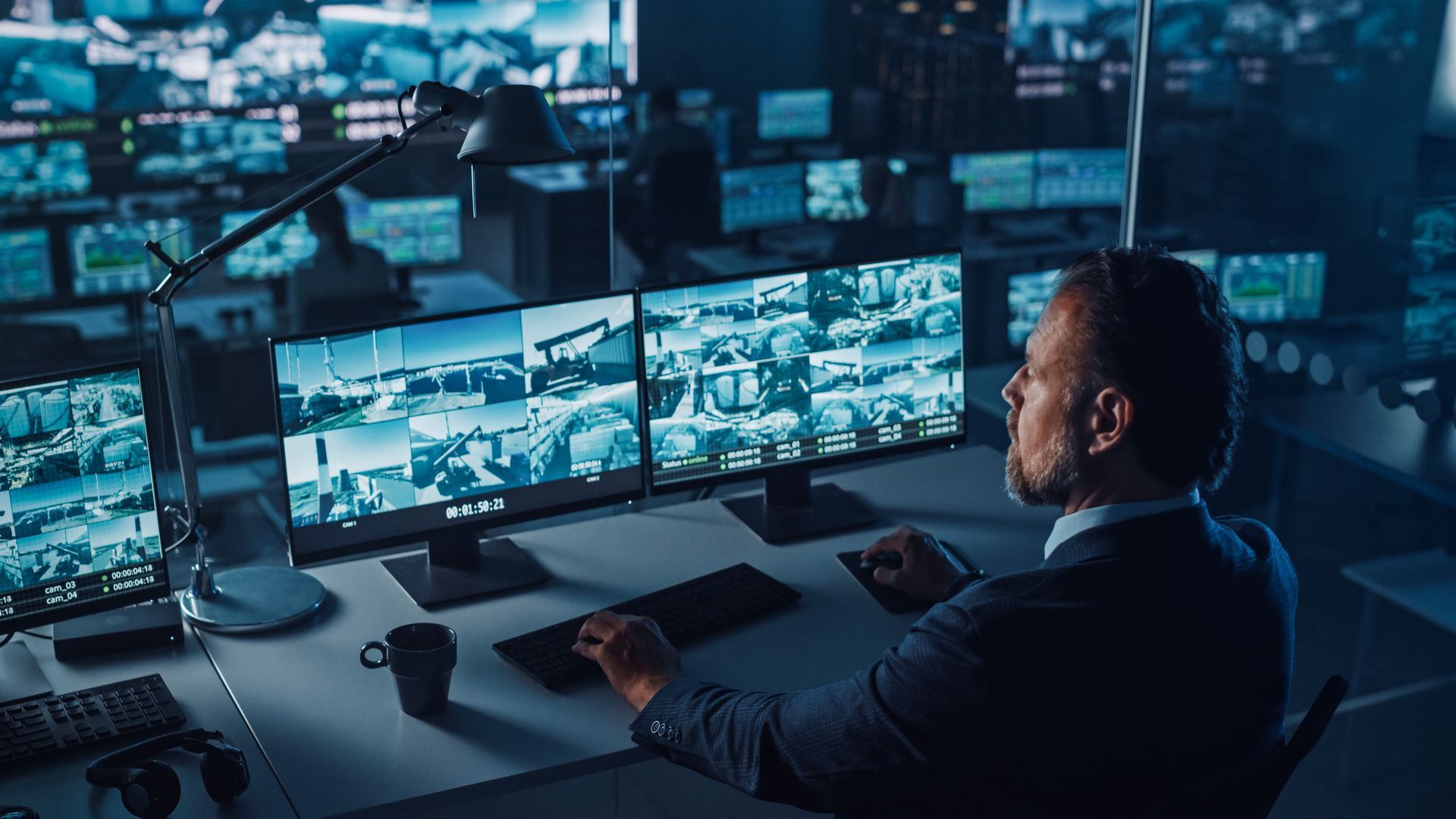A man is sitting at a desk in front of a computer monitor.