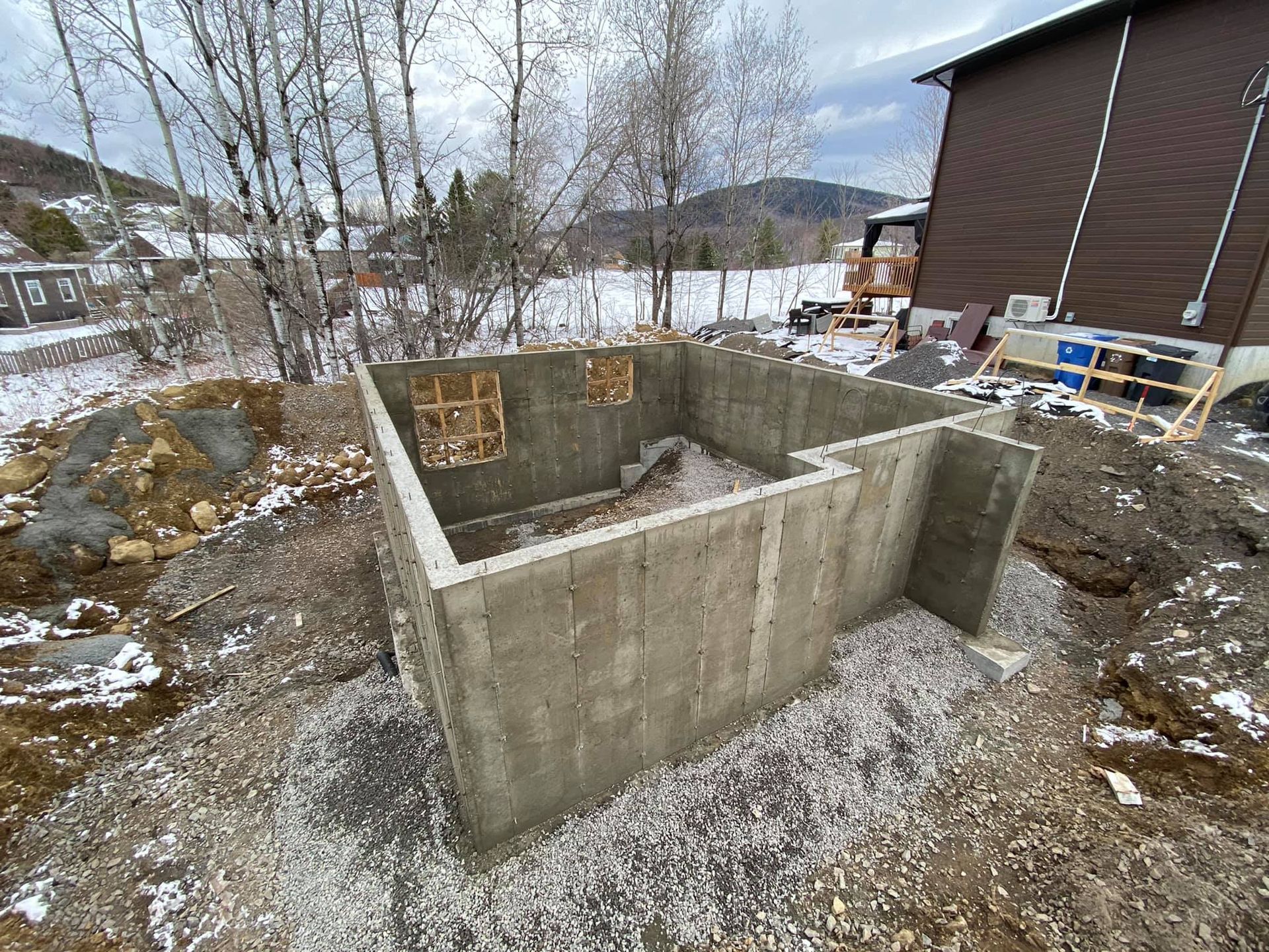 Un grand mur de béton est en train d'être construit devant une maison.