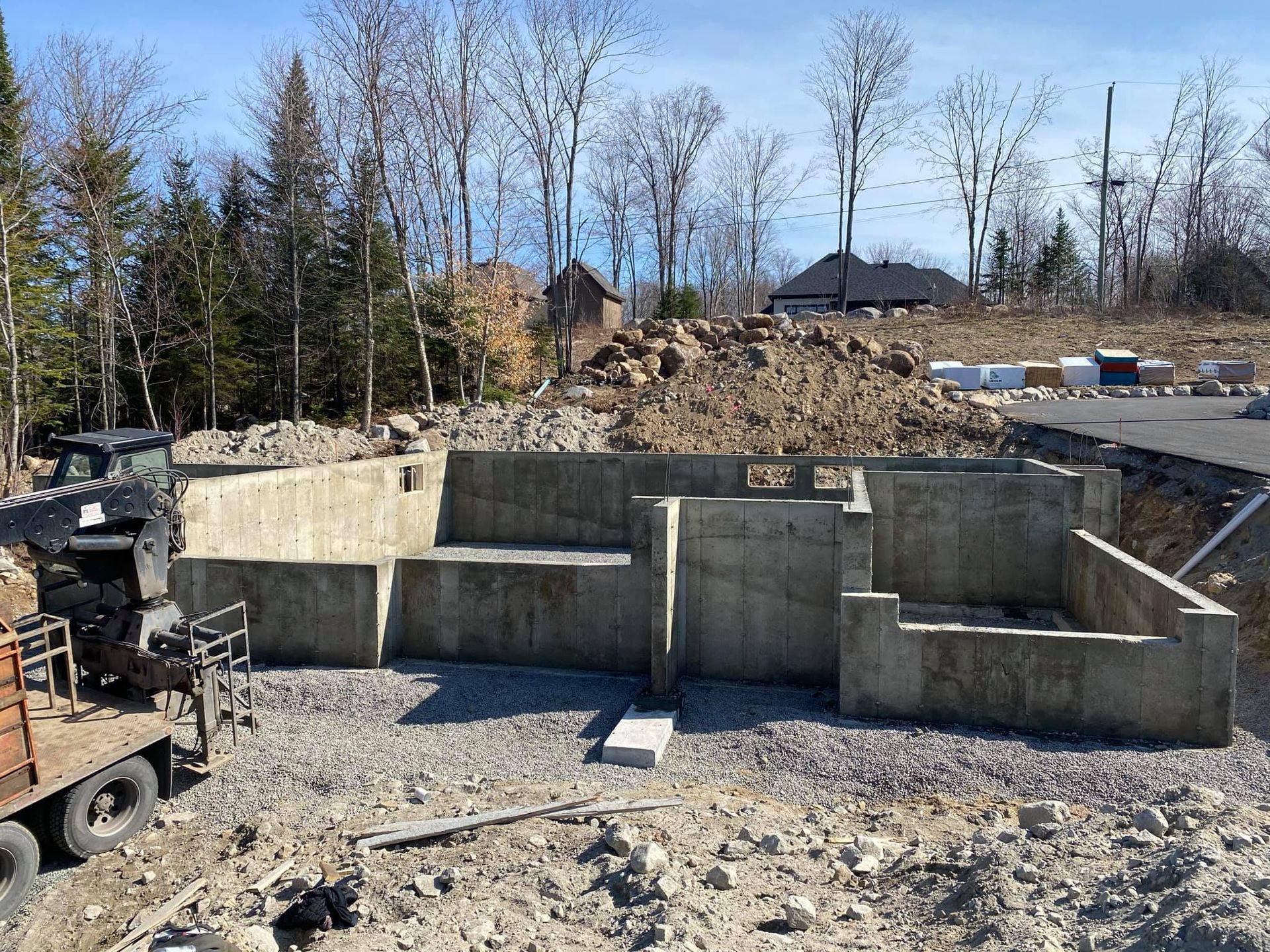Une grande fondation en béton est en cours de construction dans un champ de terre.