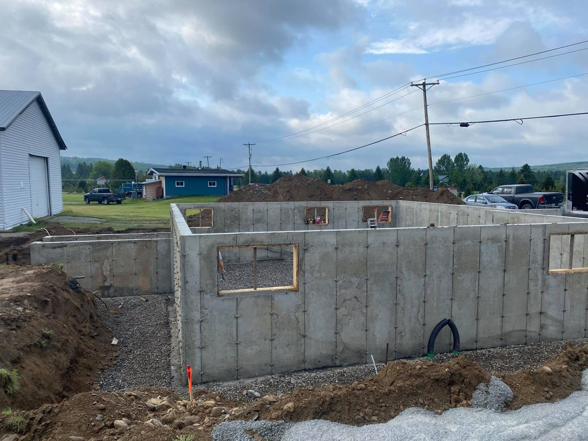Un mur de béton est en train d'être construit dans un champ de terre.