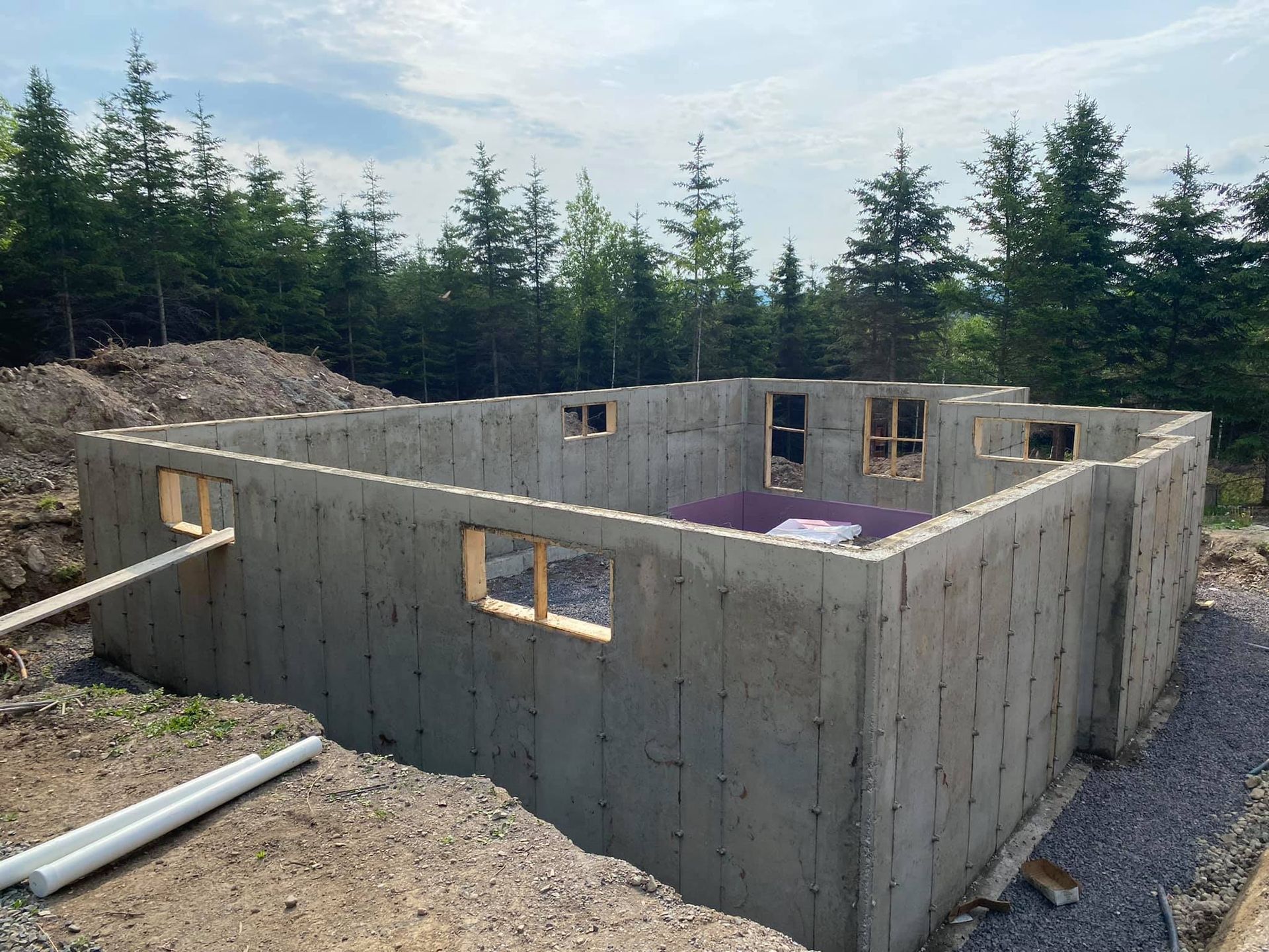 Les fondations d'une maison sont en cours de construction au milieu d'une forêt.