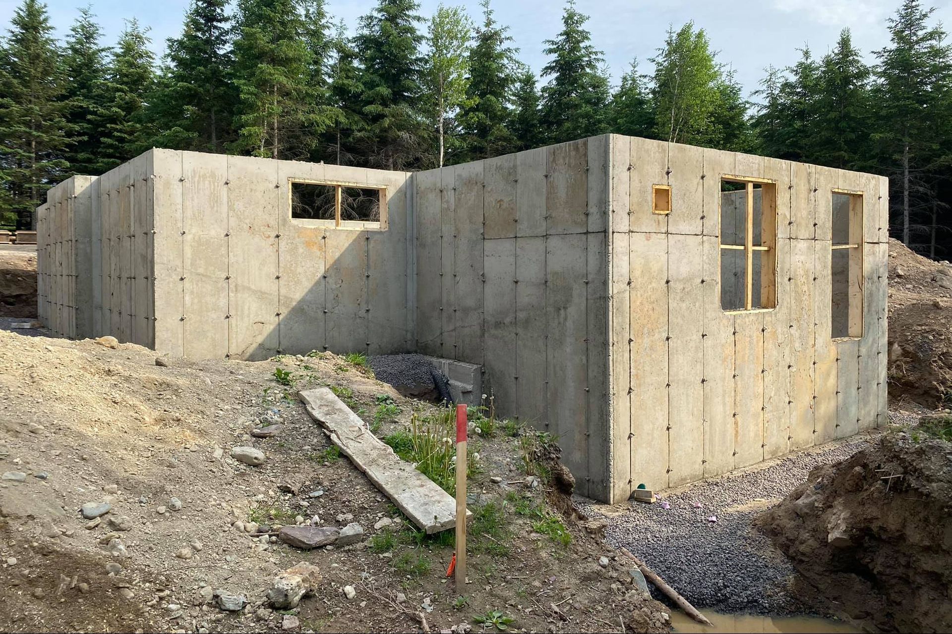 Un bâtiment en béton est en construction au milieu d'une forêt.