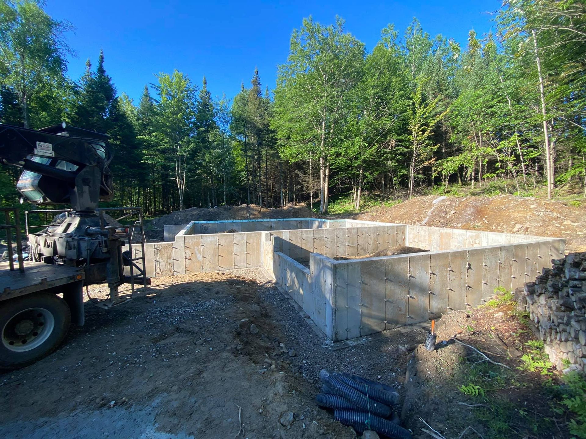 Une grande fondation en béton est en cours de construction au milieu d'une forêt.