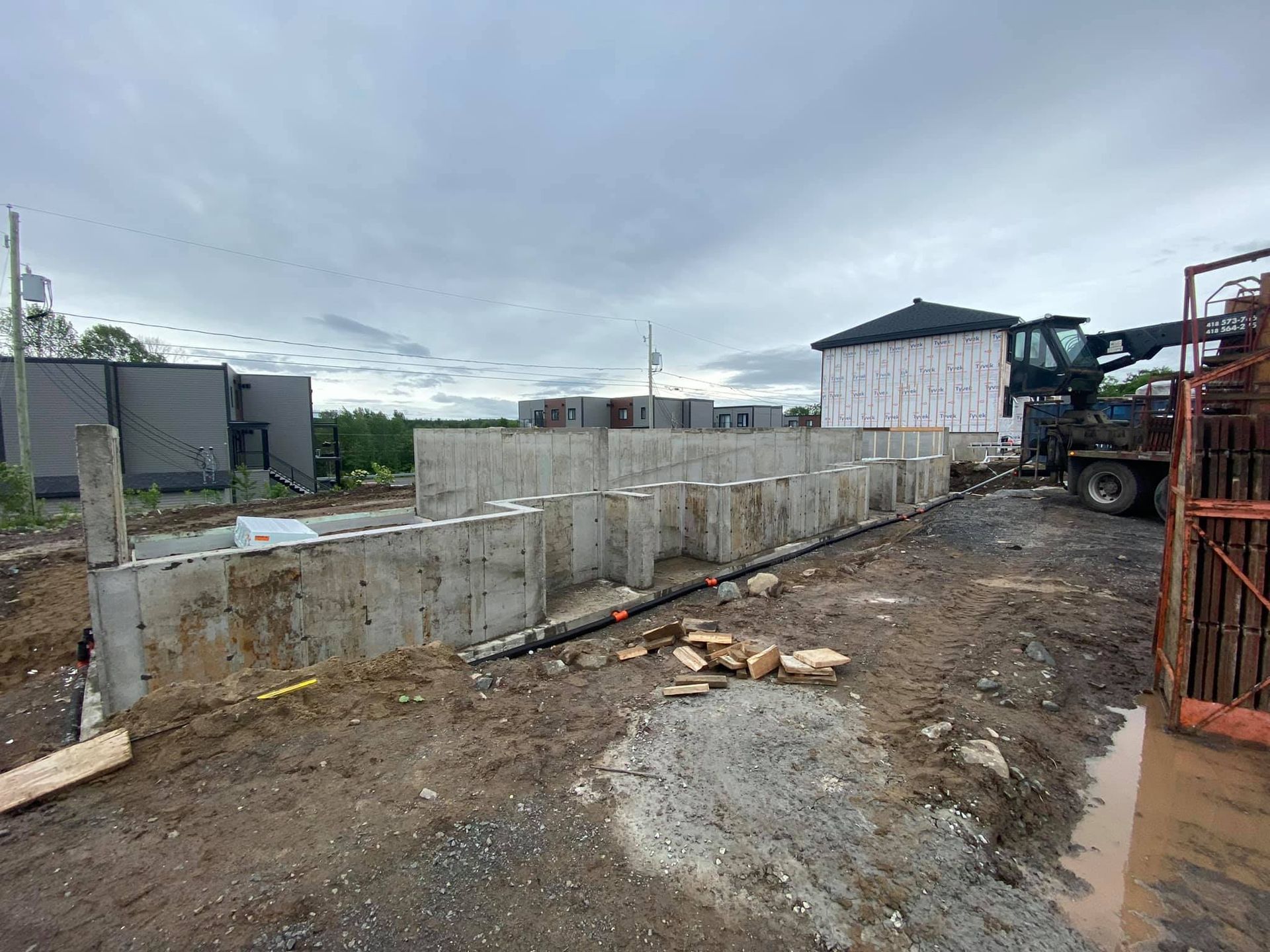 Un grand mur de béton est en cours de construction sur un chantier.