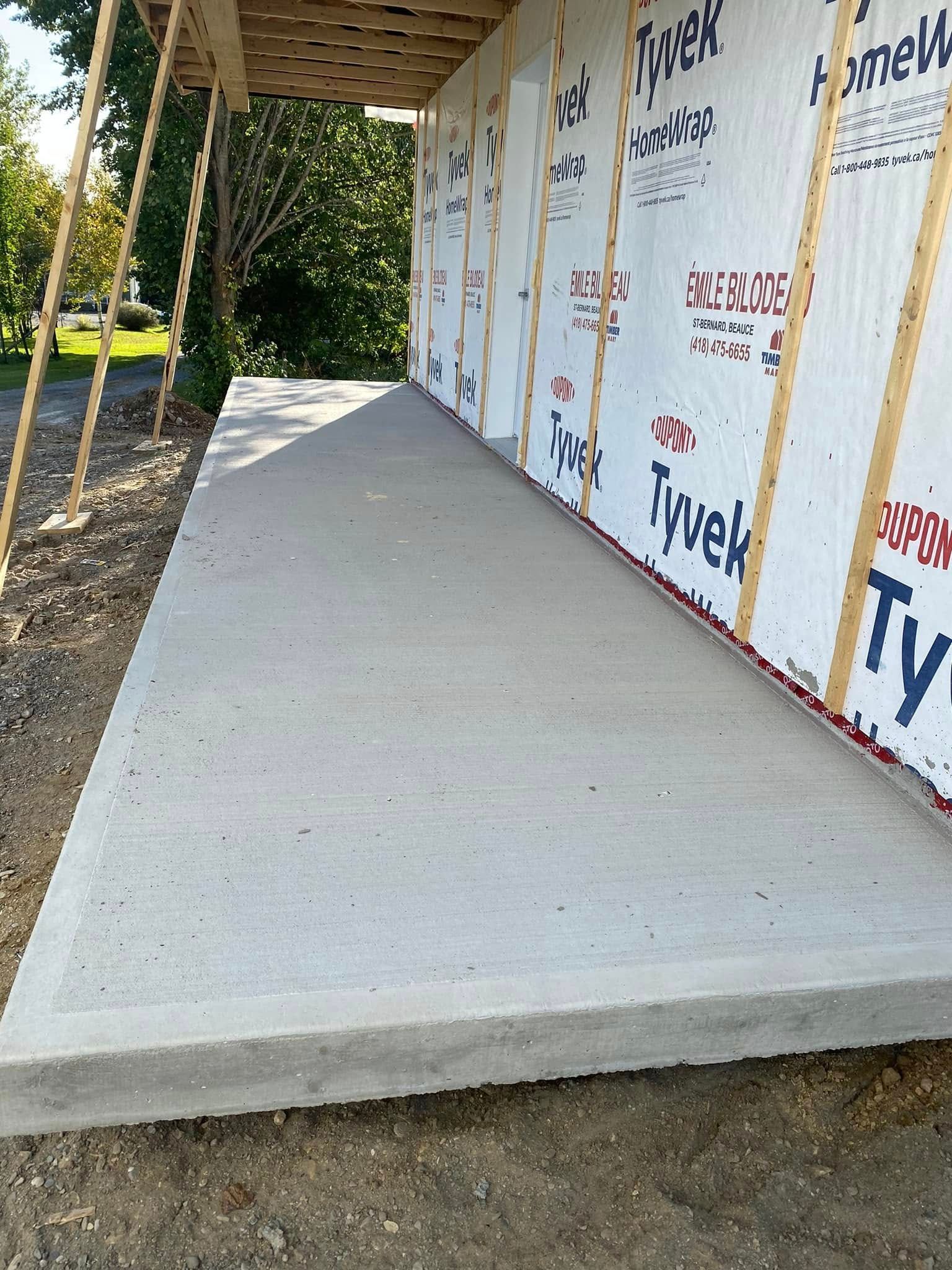 Une passerelle en béton menant à un bâtiment en construction.