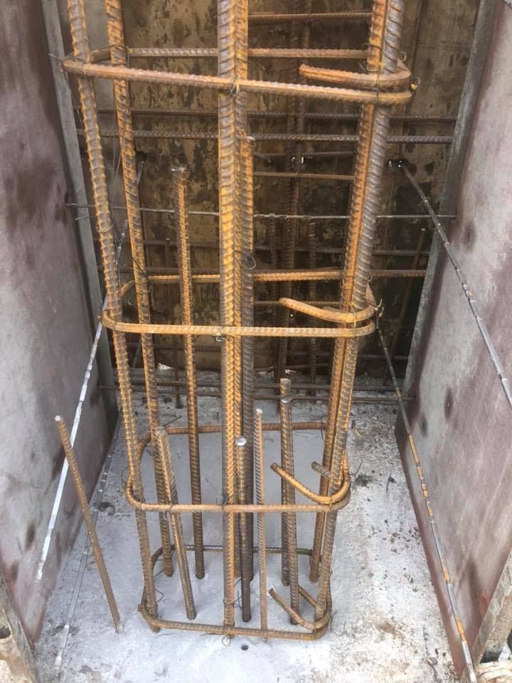 Un tas de barres métalliques reposent sur un sol en béton.