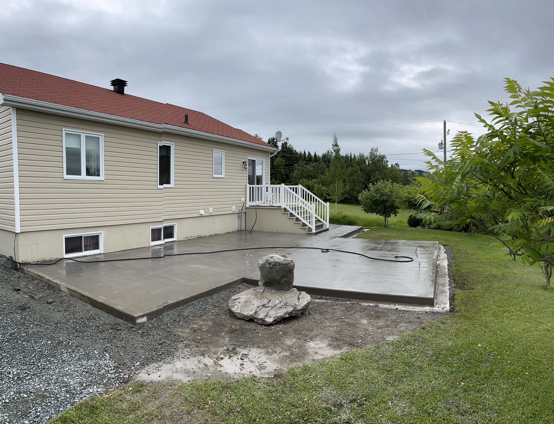 Une maison avec un patio en béton devant.