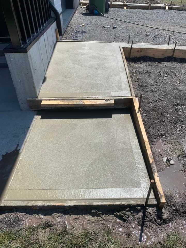 Une passerelle en béton est en cours de construction devant une maison.