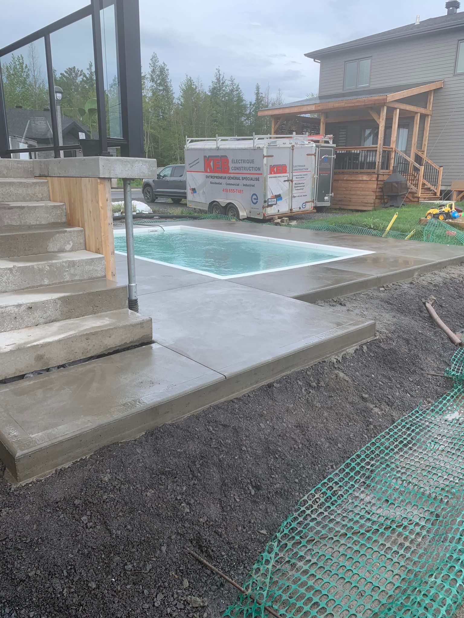 Un camion blanc est garé à côté d'une piscine dans une cour arrière.