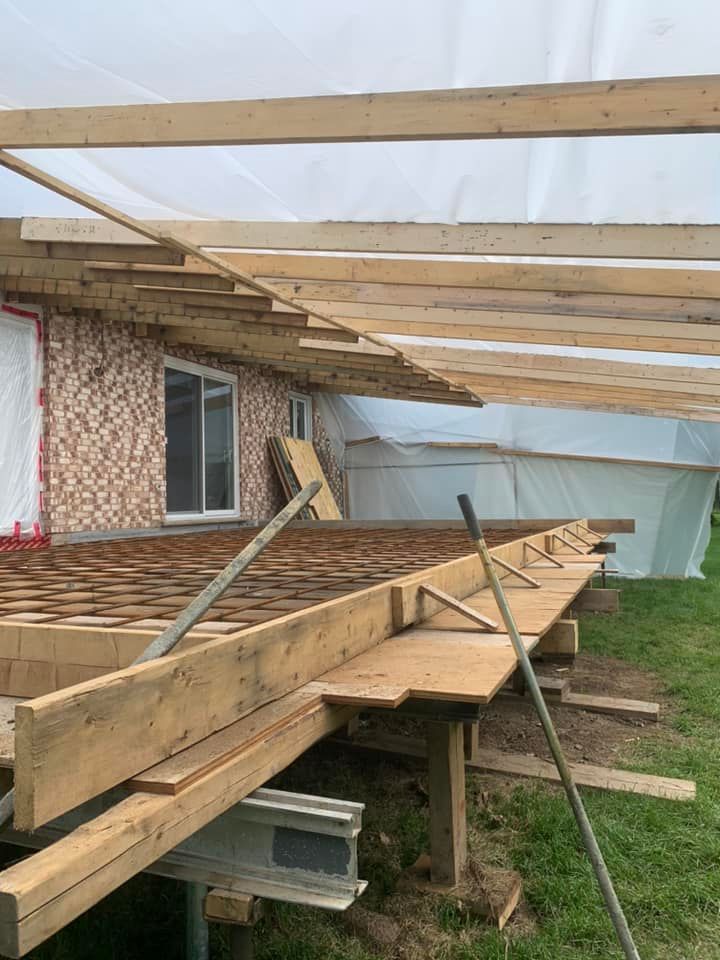 Une terrasse en bois est en cours de construction devant une maison.