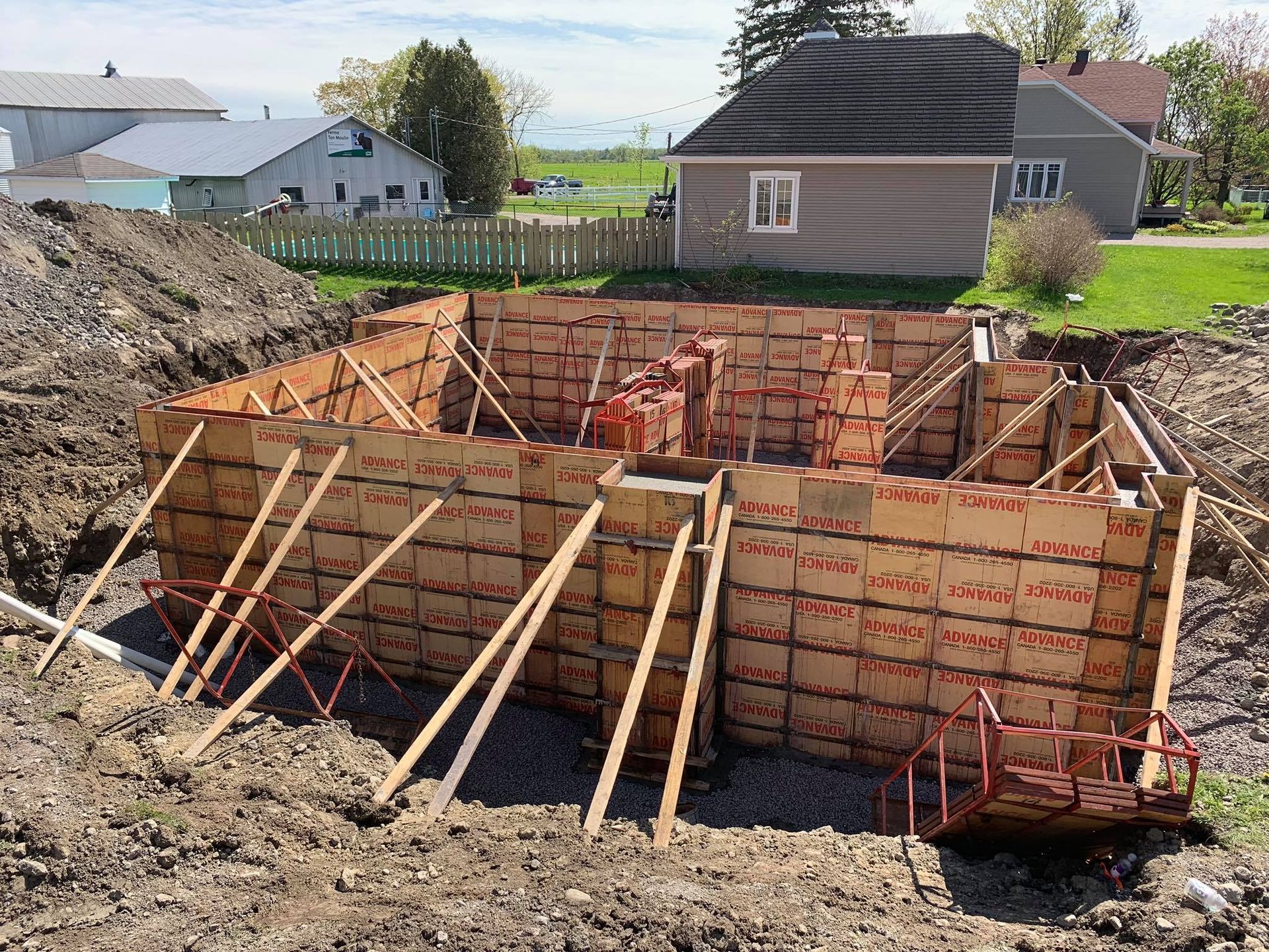 Une maison est en construction au milieu d'un champ de terre.
