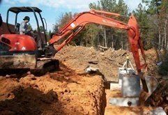 backhoe digging around septic system